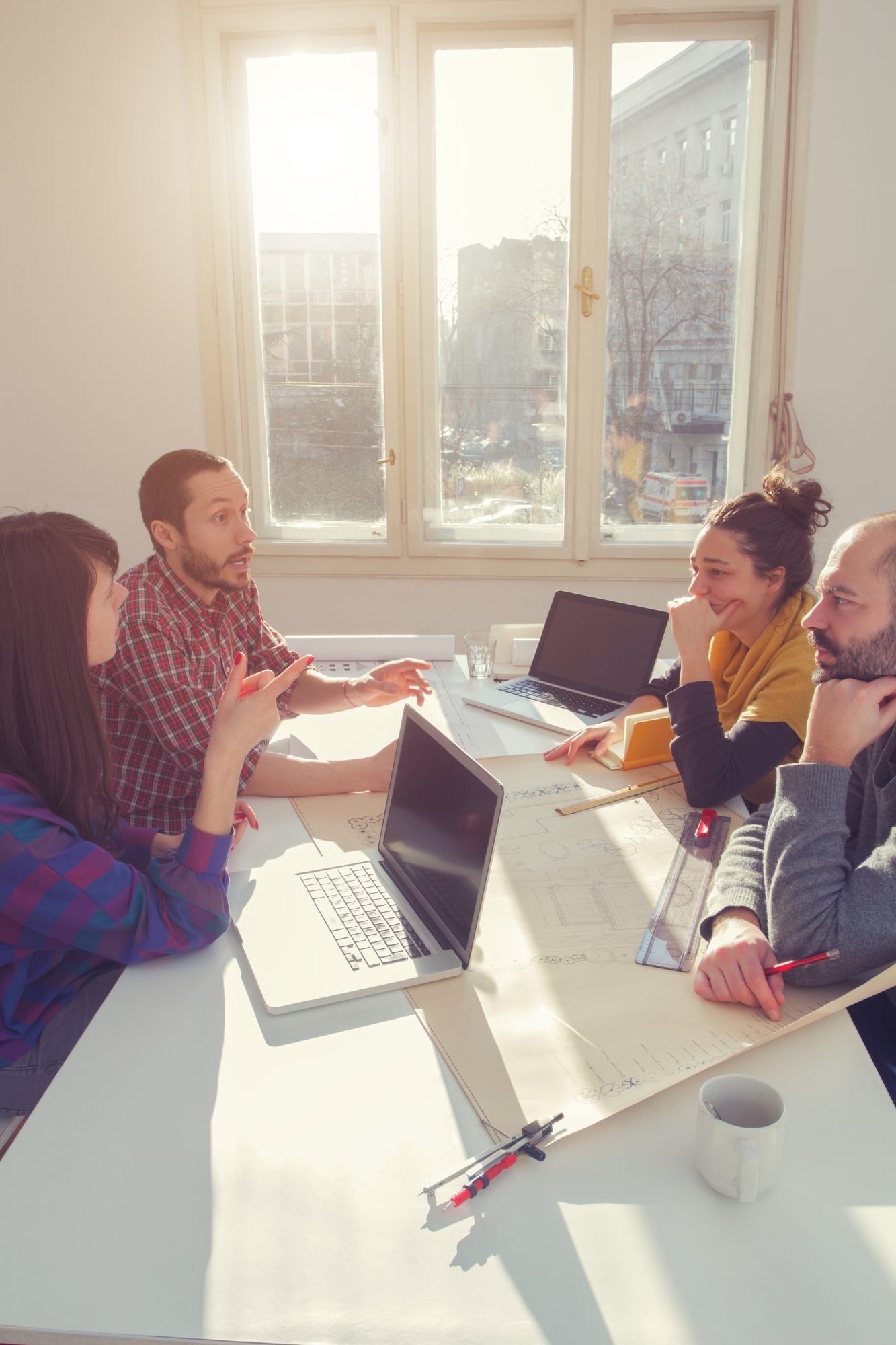 A small team working together around a table with laptops